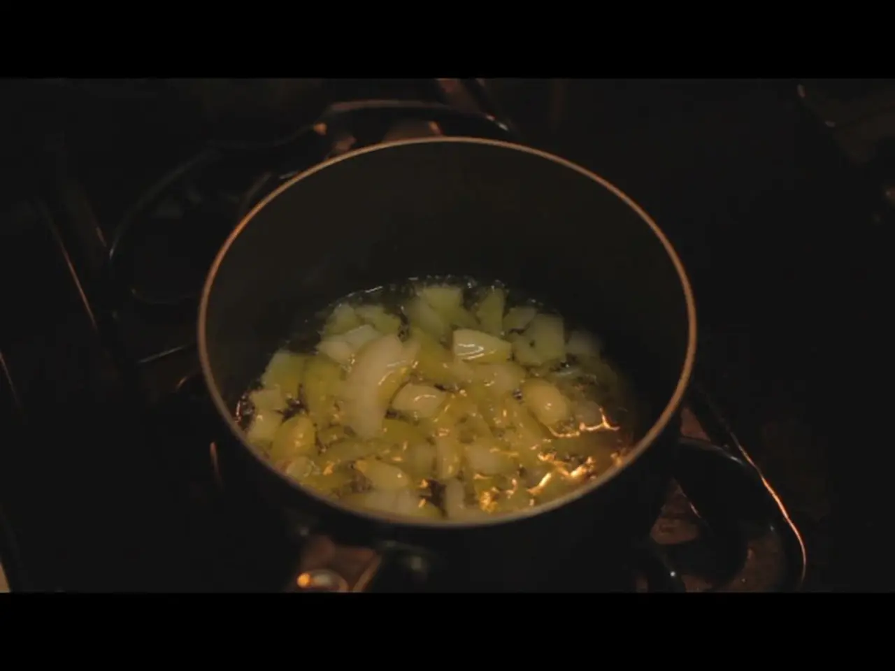 C'è una stufa e un oggetto viene cucinato in un contenitore sulla stufa.