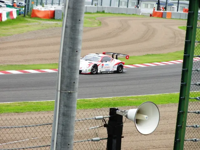 L'immagine mostra un'auto da corsa che corre su una pista con un megafono davanti. La pista è...