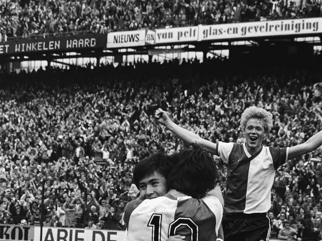 L'immagine mostra un gruppo di tre giocatori di calcio che festeggiano un gol di fronte a una...