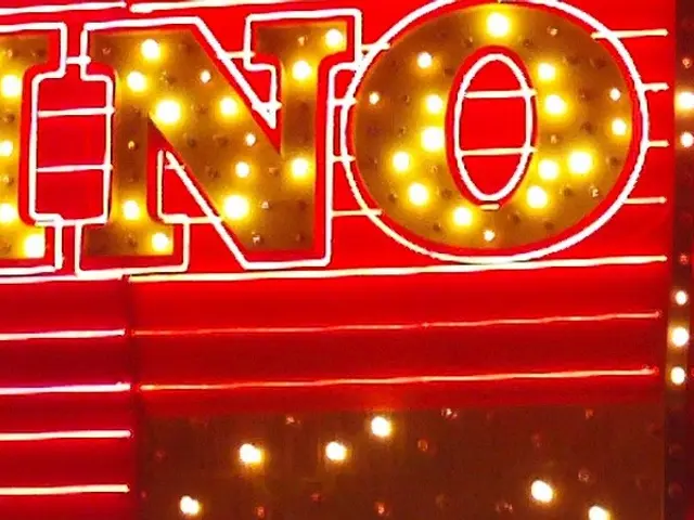 L'immagine mostra un cartellone del casinò acceso di notte di fronte a un edificio, con testo sul...